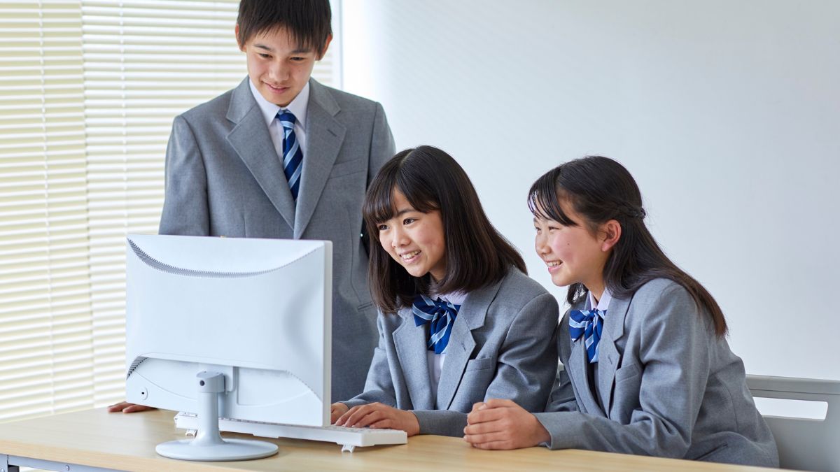 職員室でノートPCの動作を一緒に確認する男女の教員