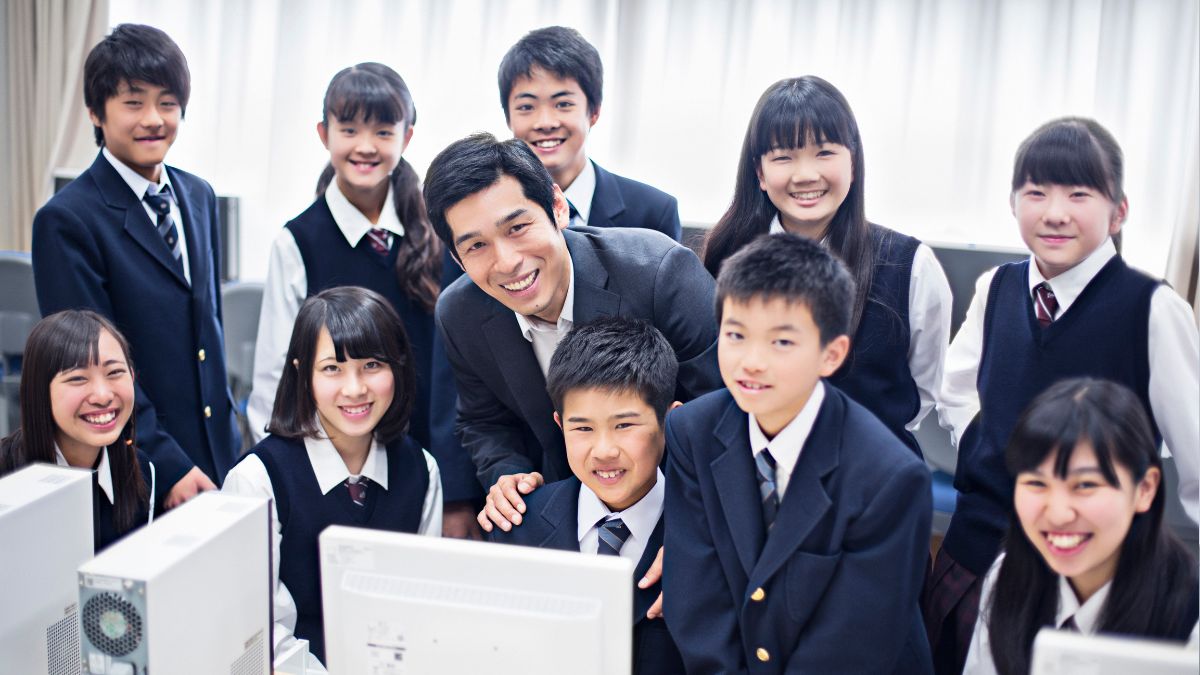 ノートパソコンを前に笑顔で打ち合わせをする教室長とスタッフ