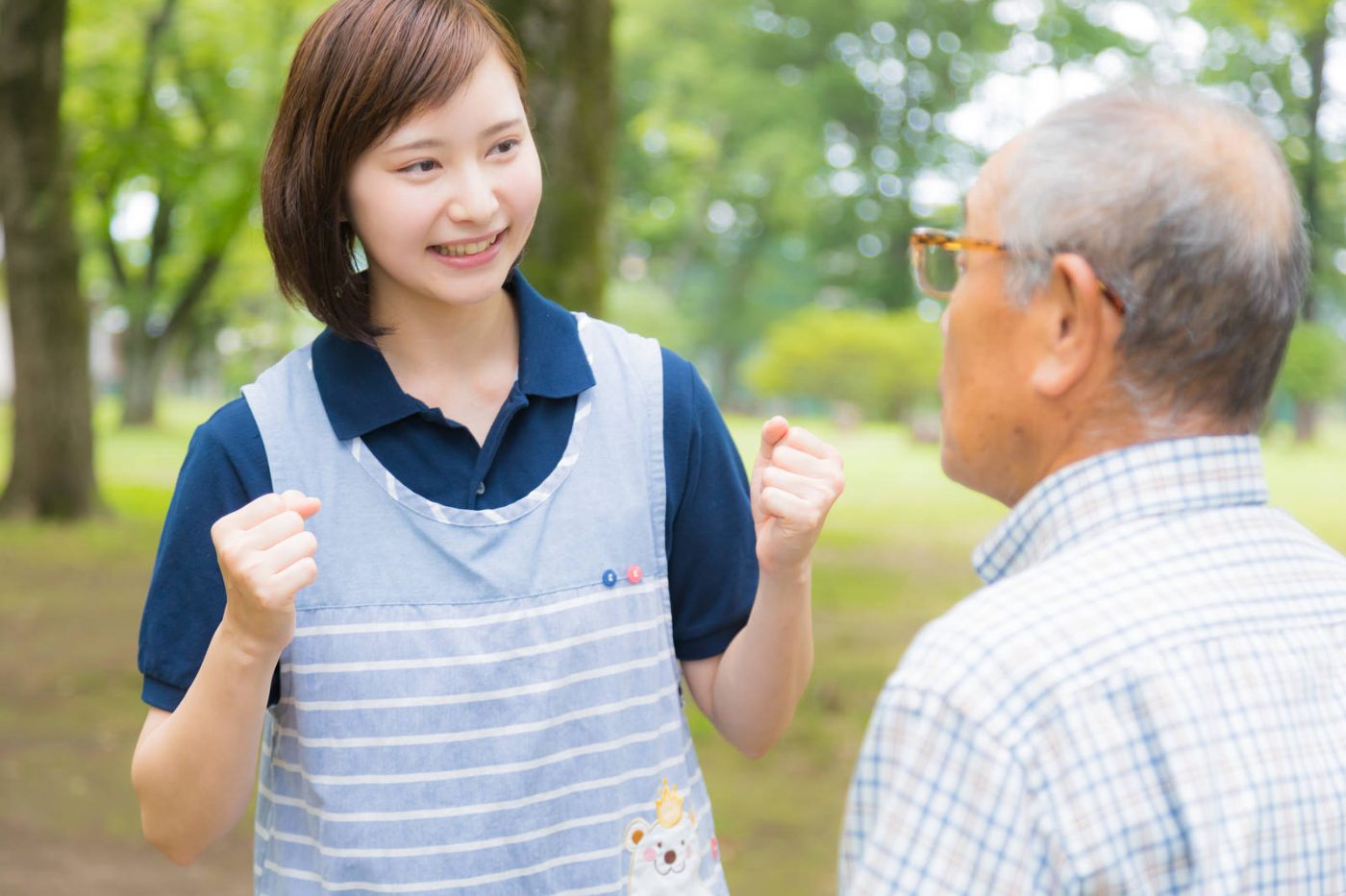 高齢者に笑顔で声をかける介護士
