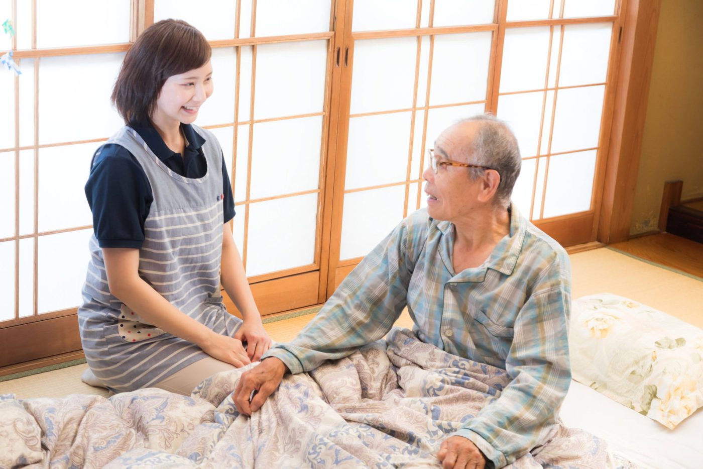 自宅で高齢者と話す介護士